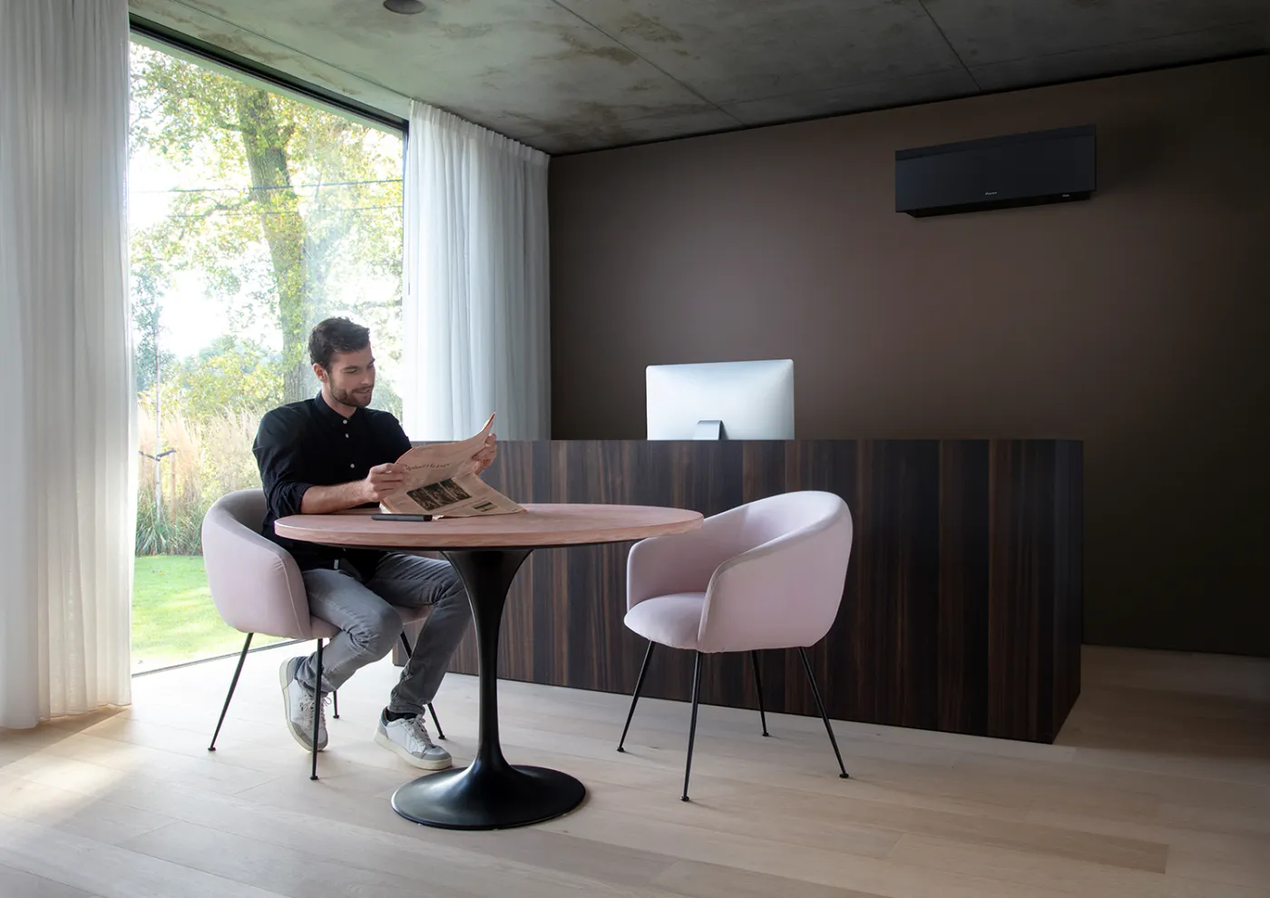 Daikin Emura i matt sort på veggen i en moderne spisestue
