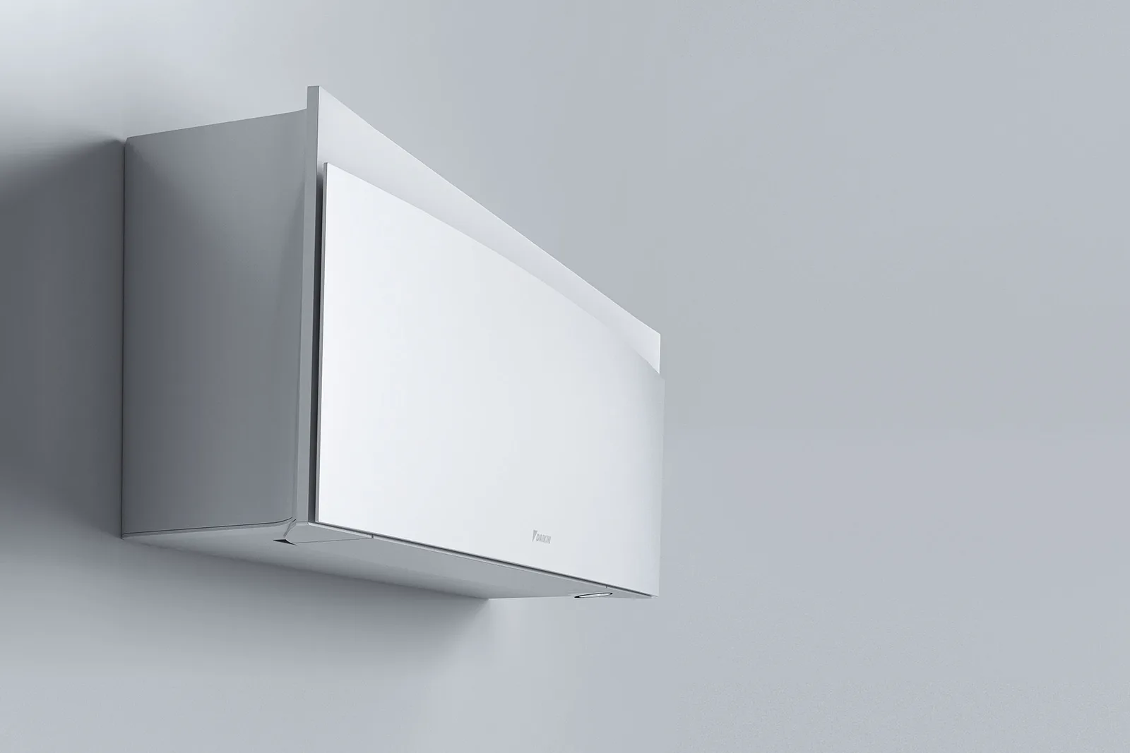 Daikin Emuras skulpturerte, buede frontpanel i matt hvit mot en lys grå vegg