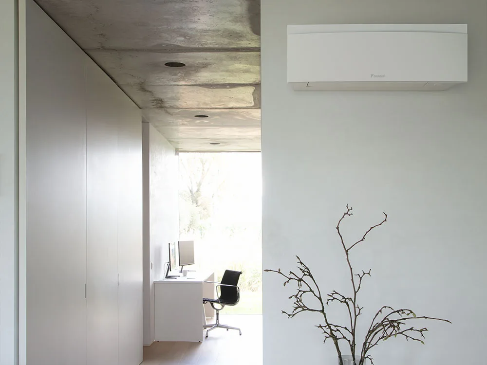 Daikin Emura i matt hvit på veggen i et lyst, minimalistisk hjem med betongtak