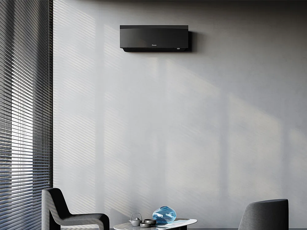 Daikin Emura i matt sort over et marmorbord mellom to grå lenestoler