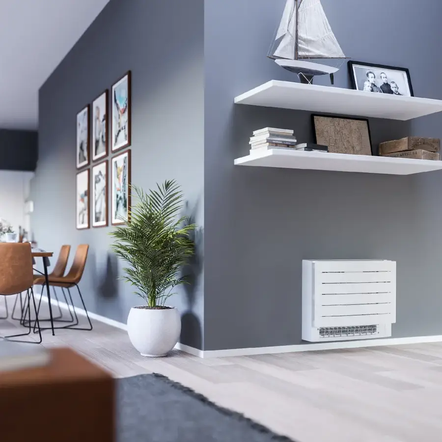 Daikin floor model low on a gray living-room wall below floating shelves