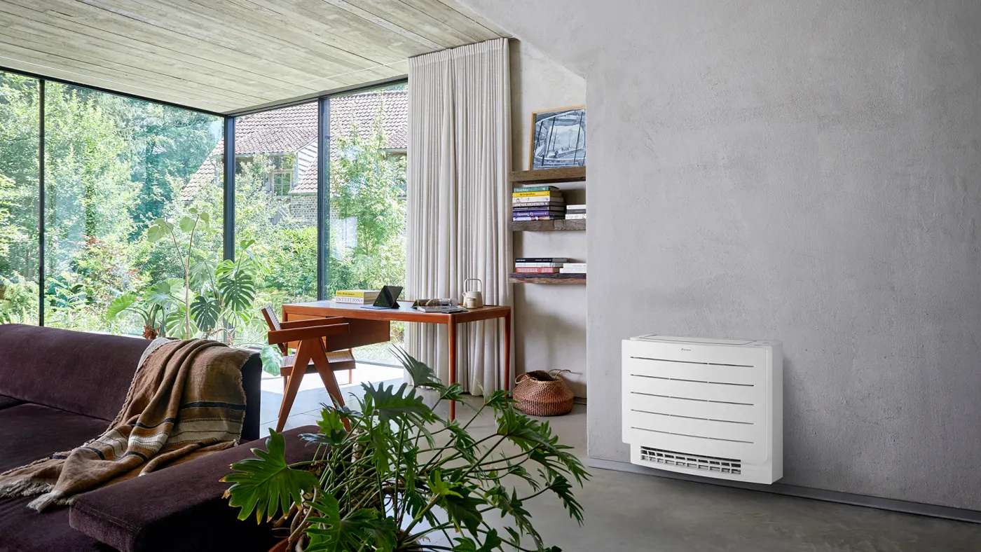 Daikin gulvmodell som smelter inn i et lyst rom med planter og en arbeidspult