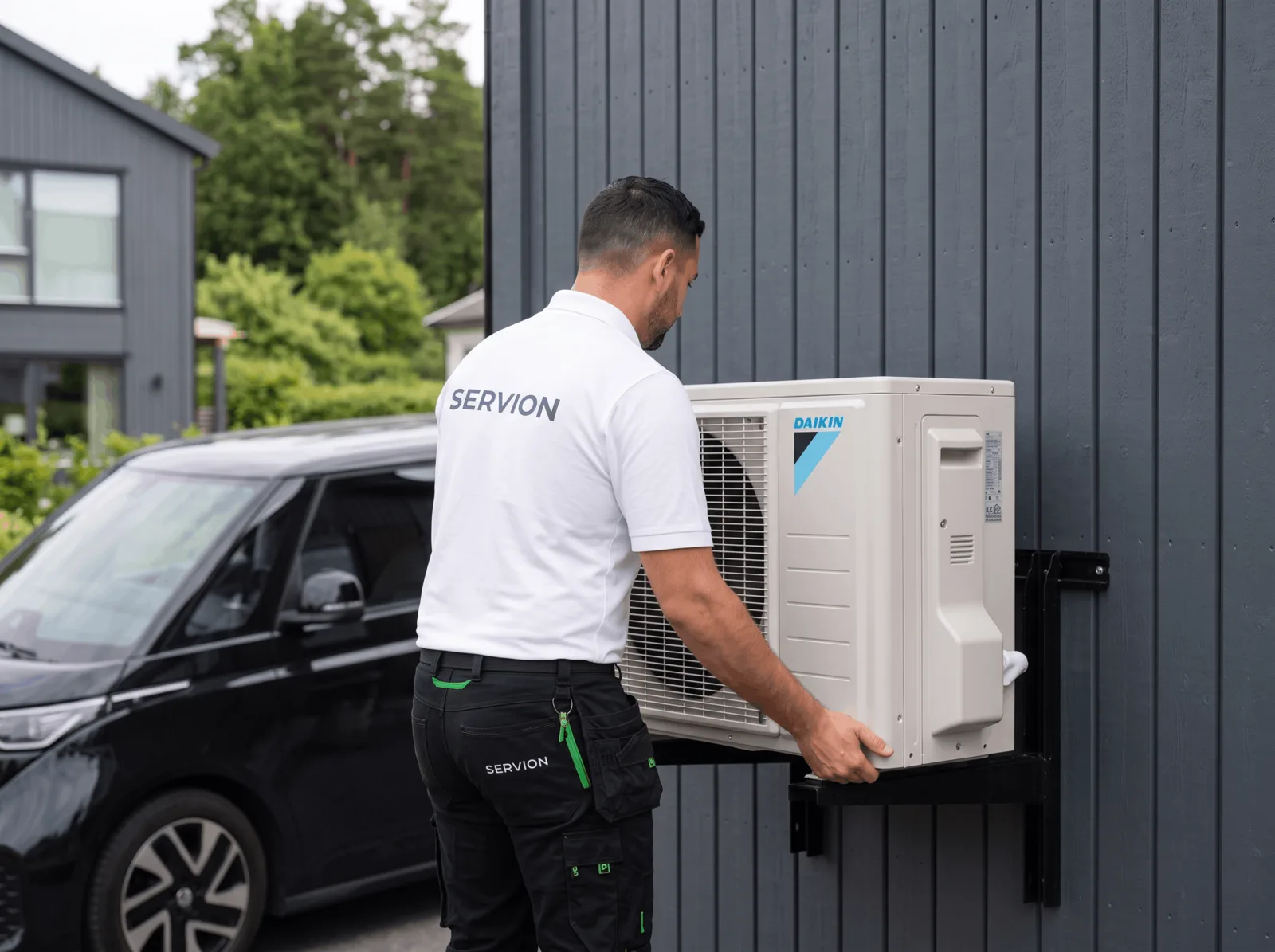 Servion technician mounting the outdoor unit on a house wall